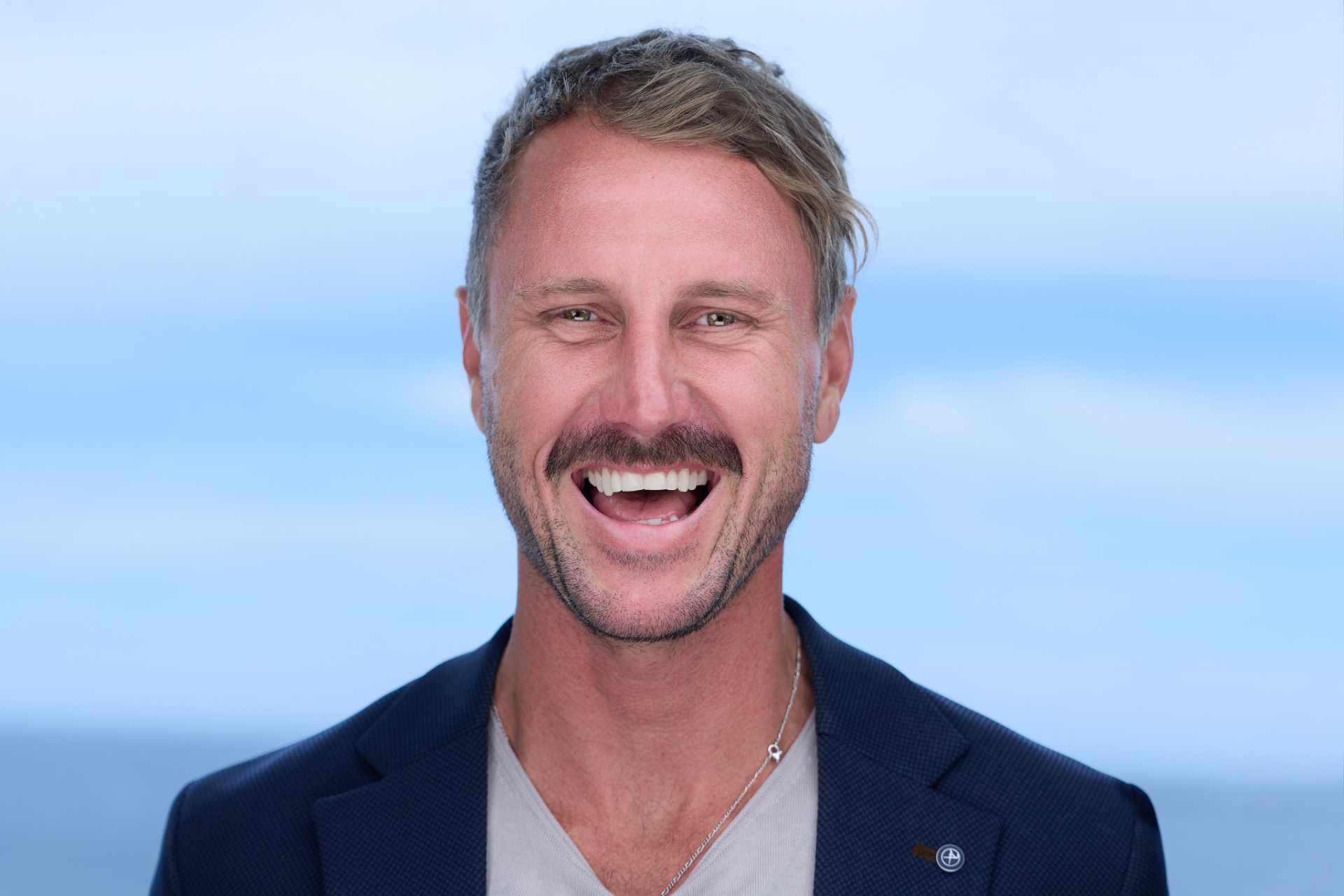 Rory Callaghan headshot, laughing, navy jacket