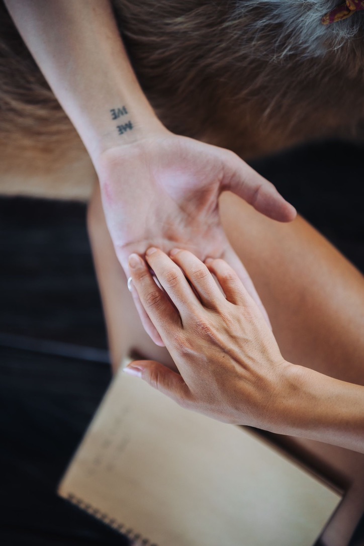 ME WE tattoo on a wrist, held by another hand