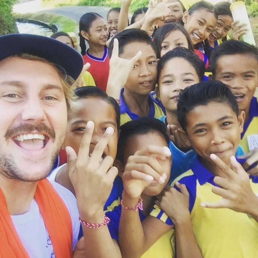 Rory with a group of smiling kids on community work